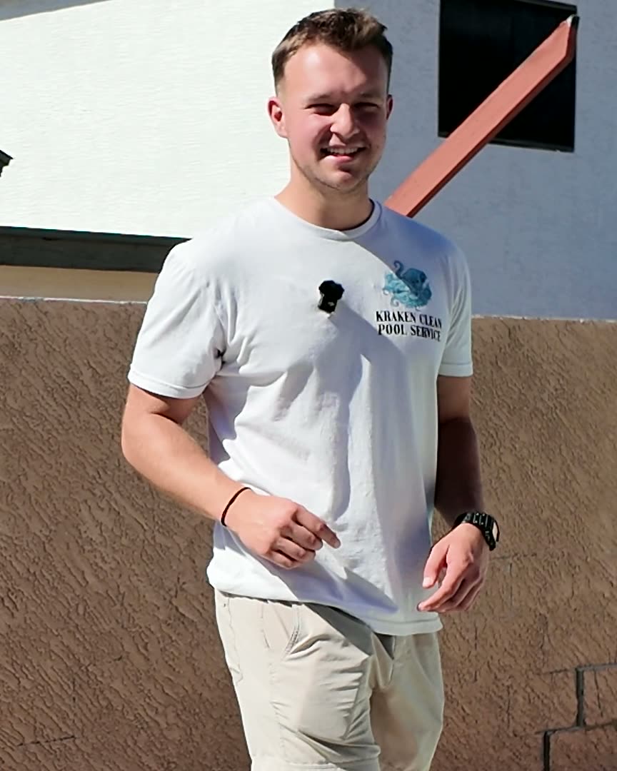 Spencer, owner of Kraken Clean AZ, standing beside a client's pool